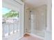 Bright bathroom features a glass shower, tile flooring, and access to an outdoor balcony with neighborhood views at 11002 Inverlochy Ct, Las Vegas, NV 89141