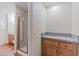 Well-lit bathroom with tiled floors, neutral cabinets with granite countertops, and a glass stand-up shower at 11002 Inverlochy Ct, Las Vegas, NV 89141