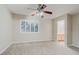 Spacious bedroom with neutral carpet, ceiling fan, and plantation shutters overlooking a bright view at 11002 Inverlochy Ct, Las Vegas, NV 89141