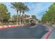 Community gatehouse entrance featuring stone architecture, mature trees, and meticulously maintained landscaping at 11002 Inverlochy Ct, Las Vegas, NV 89141