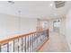 Bright hallway featuring an ornate staircase railing, neutral walls and carpets, and ample overhead lighting at 11002 Inverlochy Ct, Las Vegas, NV 89141