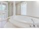Luxurious bathroom with a soaking tub, walk-in shower, and stylish glass block window at 11002 Inverlochy Ct, Las Vegas, NV 89141