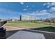 Well-maintained common area with green grass, bounded by fencing, views of mountains, and a hospital in the distance at 1135 Tektite Ave, Henderson, NV 89011