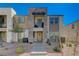 Modern townhome showcasing stone facade, covered balcony, and xeriscaped front yard at 1135 Tektite Ave, Henderson, NV 89011