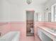 Charming pink bathroom featuring vintage tile work, bathtub, and well-lit vanity area at 1139 5Th Pl, Las Vegas, NV 89104