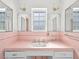 Vintage-style pink bathroom featuring unique tile work, ornate mirrors, and ample countertop space at 1139 5Th Pl, Las Vegas, NV 89104