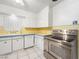 Bright kitchen featuring stainless steel appliances, white cabinets, and tile flooring at 1139 5Th Pl, Las Vegas, NV 89104