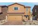 Charming two-story home featuring a tile roof, tan stucco exterior, and attached two-car garage at 1660 Desert Path Ave, North Las Vegas, NV 89032