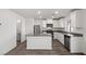 Well-appointed kitchen featuring modern island, white cabinets, stainless appliances, and laminate floors at 1660 Desert Path Ave, North Las Vegas, NV 89032