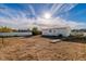 Backyard with a white house, gravel and dirt, and sparse shrubbery at 1940 Walker St, Las Vegas, NV 89106