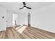 A spacious bedroom with wood-look flooring, ceiling fan, and an open doorway to a kitchen at 1940 Walker St, Las Vegas, NV 89106