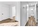 Hallway with wood-look floors leading to bedrooms and bathrooms, all with modern white walls and trim at 1940 Walker St, Las Vegas, NV 89106