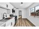Modern kitchen with stainless steel appliances, white cabinets, and wood-look flooring and a large window for lots of light at 1940 Walker St, Las Vegas, NV 89106