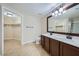 Bathroom features dual sinks, large mirror, and a walk-in closet for ample storage at 2100 Quarry Ridge St # 106, Las Vegas, NV 89117