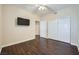 Well-lit bedroom with hardwood floors, closet, and mounted television at 2100 Quarry Ridge St # 106, Las Vegas, NV 89117