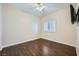 Bright bedroom features dark hardwood floors, ceiling fan, and a window with blinds at 2100 Quarry Ridge St # 106, Las Vegas, NV 89117