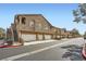 Tan multi-level apartment complex with attached garages, mature trees, and landscaping at 2100 Quarry Ridge St # 106, Las Vegas, NV 89117