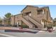 Multi-level apartment complex with tan stucco, dual staircases, and well-maintained landscaping at 2100 Quarry Ridge St # 106, Las Vegas, NV 89117