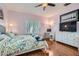 Bedroom with wooden floors, light pink walls, white furnishings, and large television at 2152 Mountain City St, Henderson, NV 89052