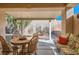 Cozy covered patio with a round wooden table and comfortable seating area, perfect for outdoor dining at 2152 Mountain City St, Henderson, NV 89052