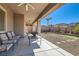 Relaxing covered patio with comfortable seating, an outdoor fireplace, and a view of the landscaped backyard at 2345 Gondi Castle Ave, Henderson, NV 89044