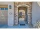 Inviting entryway with a stone archway and secure gated access to the home's front door at 2345 Gondi Castle Ave, Henderson, NV 89044