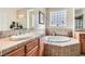 Well-lit bathroom with a soaking tub, a glass block window, and neutral tile at 2345 Gondi Castle Ave, Henderson, NV 89044