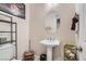 Stylish powder room featuring a pedestal sink, oval mirror, and decorative accents at 2345 Gondi Castle Ave, Henderson, NV 89044