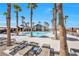 Community pool area surrounded by palm trees and lounge chairs at 2404 Elmont Ave, North Las Vegas, NV 89086