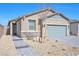 Charming single-story home with a desert-landscaped front yard and gray brick driveway under a clear blue sky at 2404 Elmont Ave, North Las Vegas, NV 89086