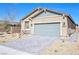 Charming single-story home with a desert-landscaped front yard and gray brick driveway under a clear blue sky at 2404 Elmont Ave, North Las Vegas, NV 89086