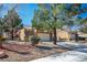 Attractive single-story home featuring a two-car garage, tidy landscaping, and mature trees at 2517 Desert Glen Dr, Las Vegas, NV 89134