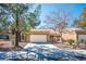 Inviting single-story home featuring a two-car garage, xeriscaping, and mature trees at 2517 Desert Glen Dr, Las Vegas, NV 89134