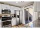 Modern kitchen with stainless steel appliances and white cabinets, featuring a sliding door to the patio at 2517 Desert Glen Dr, Las Vegas, NV 89134