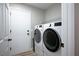 This spacious laundry room features modern washer and dryer units with shelving at 2517 Desert Glen Dr, Las Vegas, NV 89134