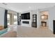 Spacious living room with wood-look tile, fireplace, and sliding glass doors leading to the backyard pool at 2587 Tolmezzo St, Henderson, NV 89044