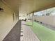 Covered backyard patio enhanced by an artificial turf area and brick flooring at 3581 Rio Paloma Ct, North Las Vegas, NV 89031