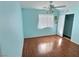 Bright bedroom with blue walls, wood floors, a ceiling fan, and a window dressed with white shutters at 3581 Rio Paloma Ct, North Las Vegas, NV 89031