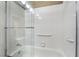 Bright bathroom showcasing a tub with sliding glass door and wall-mounted grab bars at 4033 Bliss Canyon Ct, Las Vegas, NV 89129