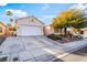 Exterior view of a single-story home with a two-car garage and desert landscaping at 4033 Bliss Canyon Ct, Las Vegas, NV 89129