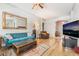Spacious living room featuring hardwood floors, a comfortable blue sofa, and large windows at 4033 Bliss Canyon Ct, Las Vegas, NV 89129