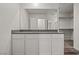 Modern bathroom vanity with white cabinetry, a gray countertop, and a large mirror at 4224 Golden Sol St, North Las Vegas, NV 89032