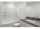Clean bathroom featuring a shower-tub combo with white tile and a vanity with gray countertop at 4224 Golden Sol St, North Las Vegas, NV 89032