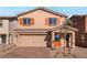 Charming two-story home with a two-car garage, desert landscaping, and stylish orange shutters and door at 4224 Golden Sol St, North Las Vegas, NV 89032