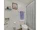 Simple bathroom featuring a toilet with white cabinets and a shower with a striped shower curtain at 527 Clearsable Ave, Henderson, NV 89044