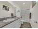Bright bathroom featuring a granite countertop, white cabinets, and glass-enclosed shower with a sliding door at 527 Clearsable Ave, Henderson, NV 89044