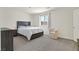 Bedroom features a large window with blinds, a dresser and nightstand, a white bedspread, and gray carpet at 527 Clearsable Ave, Henderson, NV 89044