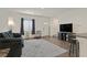 Living room features gray walls, a large window with blinds, and a plush sofa and chair at 527 Clearsable Ave, Henderson, NV 89044
