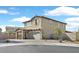A charming two-story home with a stone-accented facade, a two-car garage, and a circular driveway at 625 Honesty Ct, Henderson, NV 89011