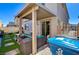 Inviting backyard features a covered patio with outdoor seating and artificial grass at 6747 Marjoram St, Las Vegas, NV 89166